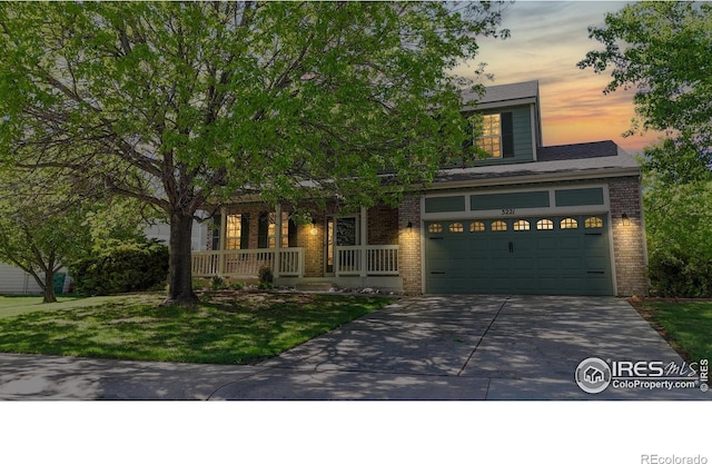 3221 Mesa Verde St, Fort Collins, CO 80525 - view of front of house featuring driveway, brick siding, a porch, a garage, and a lawn