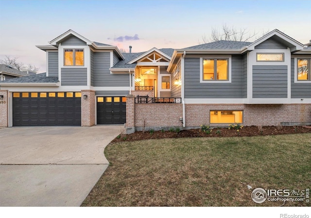 990 Utica Cir, Boulder, CO 80304 - view of front of house with a garage, a front lawn, concrete driveway, brick siding, and roof with shingles