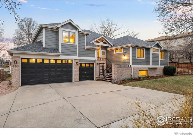 990 Utica Cir, Boulder, CO 80304 - view of front facade featuring brick siding, driveway, fence, and roof with shingles