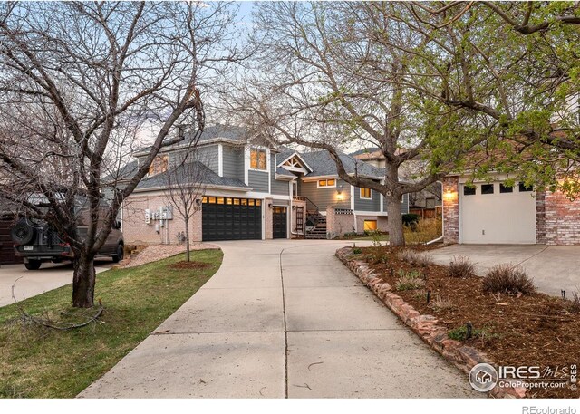 990 Utica Cir, Boulder, CO 80304 - view of front facade with driveway, brick siding, and an attached garage
