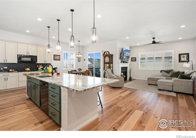 5524 Congressional Ct, Windsor, CO 80528 - kitchen with a sink, open floor plan, black appliances, white cabinetry, and recessed lighting