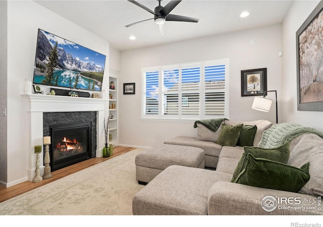 5524 Congressional Ct, Windsor, CO 80528 - living area featuring a ceiling fan, wood finished floors, a stone fireplace, baseboards, and recessed lighting