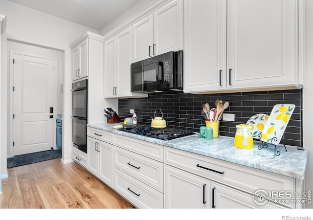 5524 Congressional Ct, Windsor, CO 80528 - kitchen with black appliances, white cabinets, light wood-style floors, backsplash, and light stone countertops