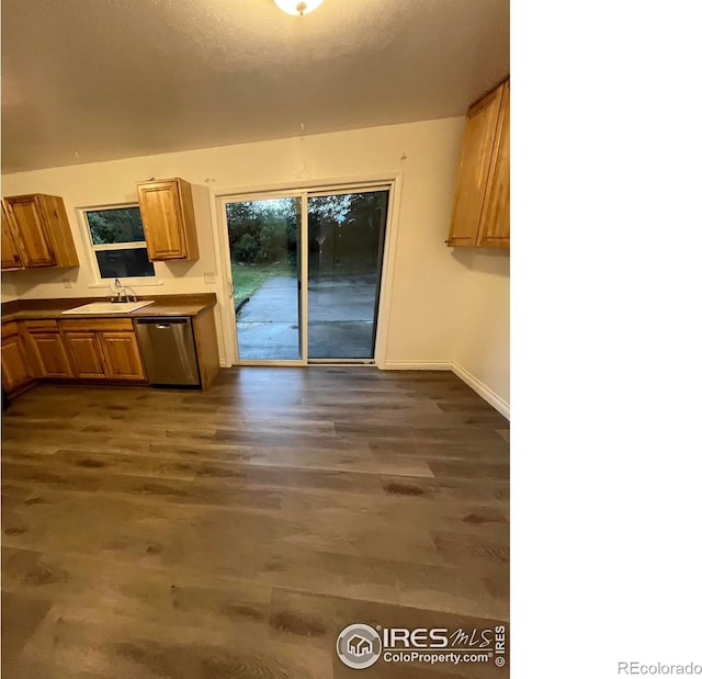 12820 Dexter St, Thornton, CO 80241 - kitchen featuring stainless steel dishwasher, a sink, dark wood-style flooring, baseboards, and brown cabinets