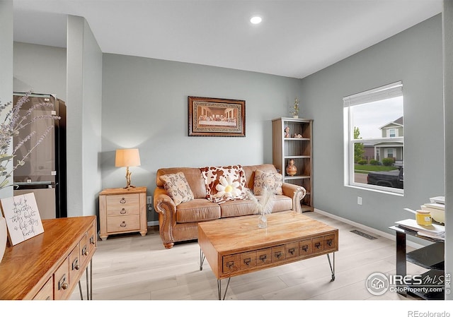 living room with light wood finished floors and recessed lighting
