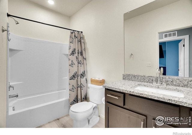 full bath with toilet, vanity, shower / bath combo with shower curtain, wood finished floors, and baseboards