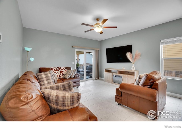 living room with ceiling fan, light tile patterned floors, and baseboards