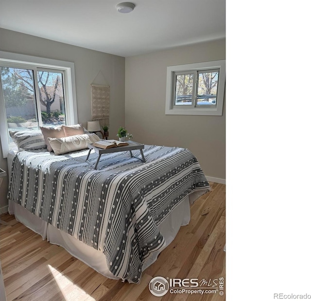 1225 Ithaca Dr, Boulder, CO 80305 - bedroom featuring multiple windows, wood finished floors, and baseboards
