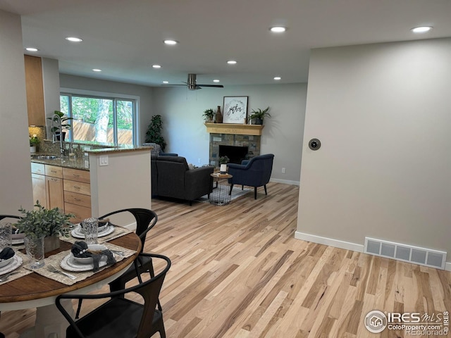 1225 Ithaca Dr, Boulder, CO 80305 - dining area featuring light wood finished floors, a stone fireplace, recessed lighting, and baseboards