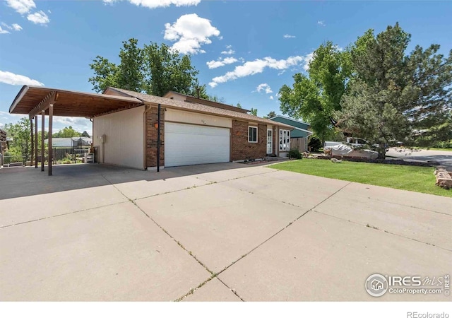 316 43rd Avenue Ct, Greeley, CO 80634 - view of front of property featuring driveway, a garage, brick siding, and a front lawn
