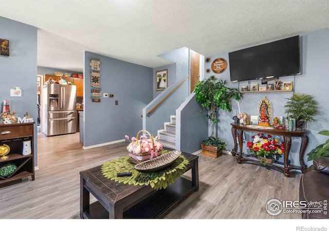 316 43rd Avenue Ct, Greeley, CO 80634 - living area featuring wood finished floors, stairs, baseboards, and a textured ceiling
