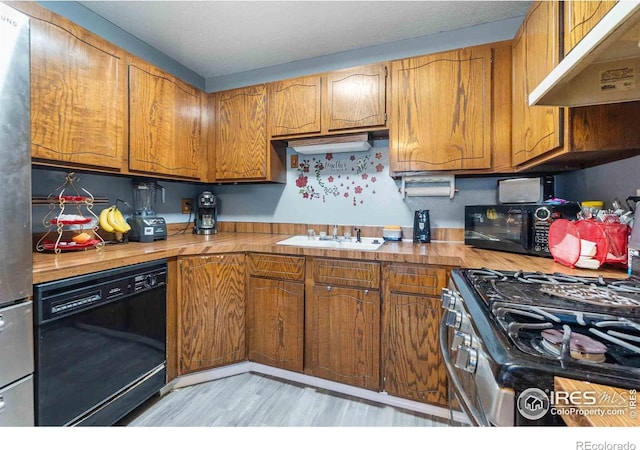 316 43rd Avenue Ct, Greeley, CO 80634 - kitchen with under cabinet range hood, black appliances, brown cabinets, a sink, and light wood finished floors