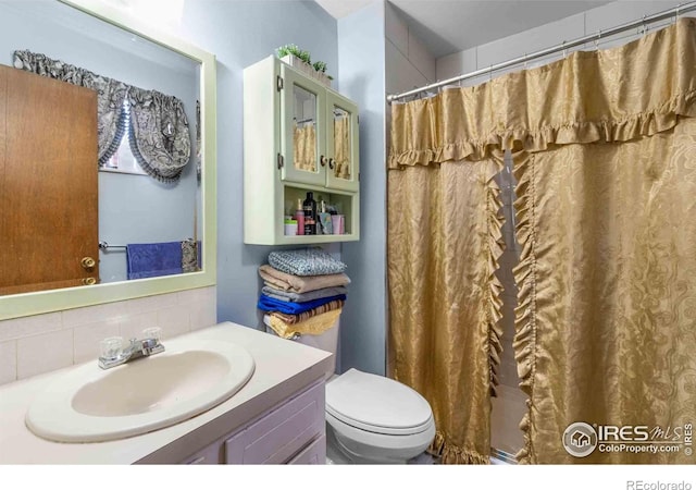 316 43rd Avenue Ct, Greeley, CO 80634 - full bathroom featuring tasteful backsplash, toilet, vanity, and curtained shower
