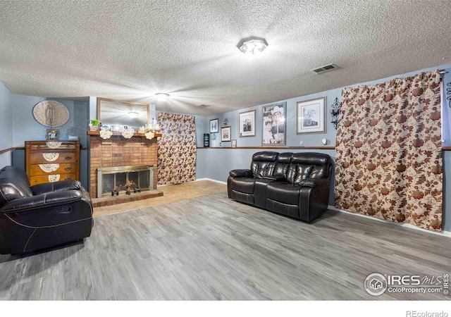 316 43rd Avenue Ct, Greeley, CO 80634 - living area with wood finished floors, a textured ceiling, baseboards, and a fireplace