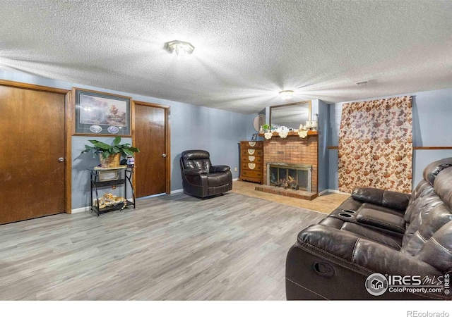 316 43rd Avenue Ct, Greeley, CO 80634 - living area with wood finished floors, a fireplace, baseboards, and a textured ceiling