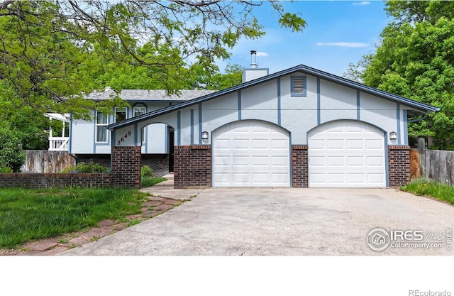 2648 Bradbury Ct, Fort Collins, CO 80521 - view of front of home with brick siding, driveway, a chimney, an attached garage, and stucco siding