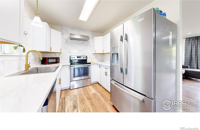 2648 Bradbury Ct, Fort Collins, CO 80521 - kitchen featuring appliances with stainless steel finishes, a sink, light wood finished floors, light countertops, and backsplash