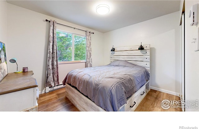 2648 Bradbury Ct, Fort Collins, CO 80521 - bedroom with a baseboard heating unit, light wood finished floors, and baseboards