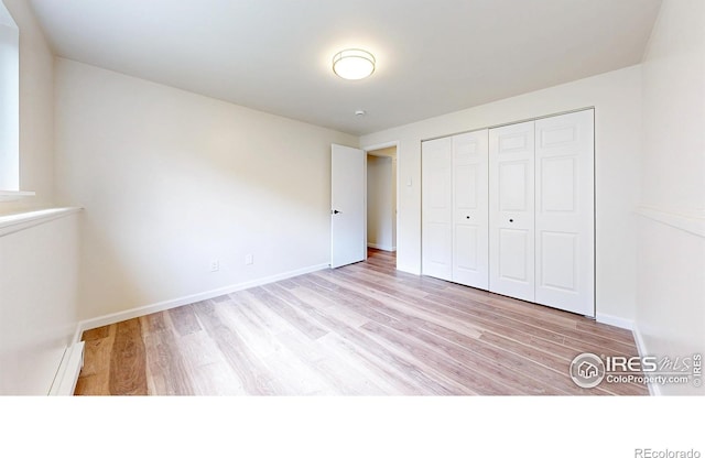 2648 Bradbury Ct, Fort Collins, CO 80521 - unfurnished bedroom featuring wood finished floors, a closet, and baseboards
