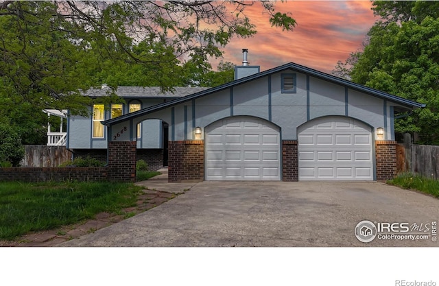 2648 Bradbury Ct, Fort Collins, CO 80521 - view of front of house featuring brick siding, a garage, driveway, a chimney, and stucco siding
