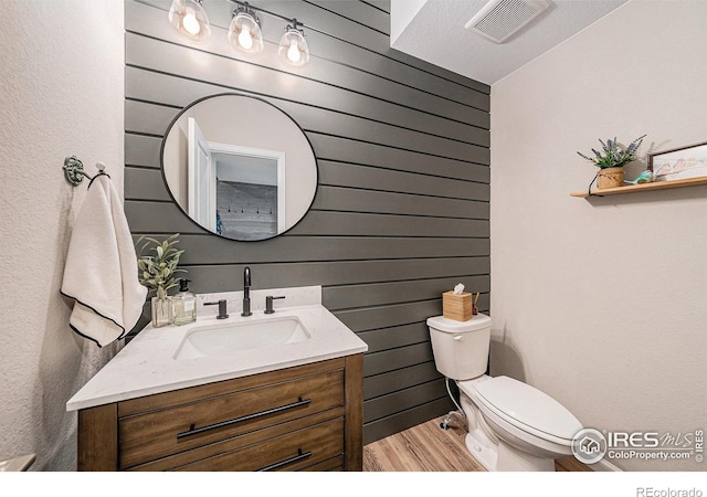 6009 Autumn Breeze Ct, Fort Collins, CO 80528 - half bath with vanity, wood finished floors, toilet, and wood walls