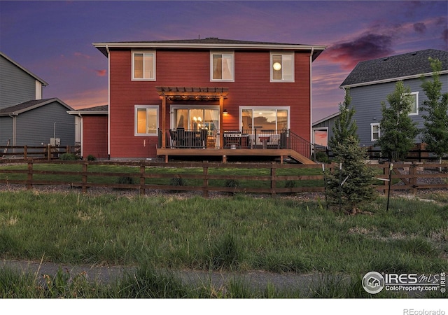 6009 Autumn Breeze Ct, Fort Collins, CO 80528 - back of house at dusk featuring a wooden deck, a fenced backyard, and a pergola