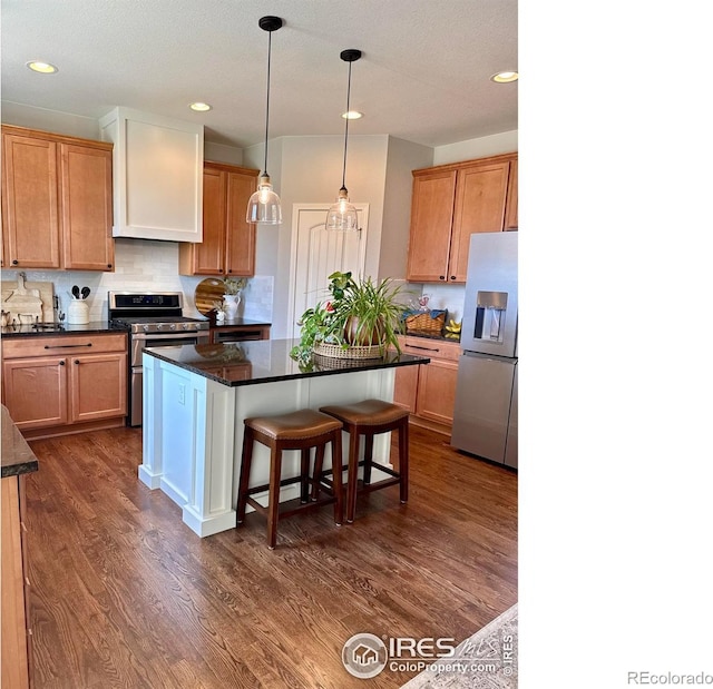 8241 White Owl Ct, Windsor, CO 80550 - kitchen with appliances with stainless steel finishes, dark wood-style flooring, a center island, a breakfast bar area, and backsplash