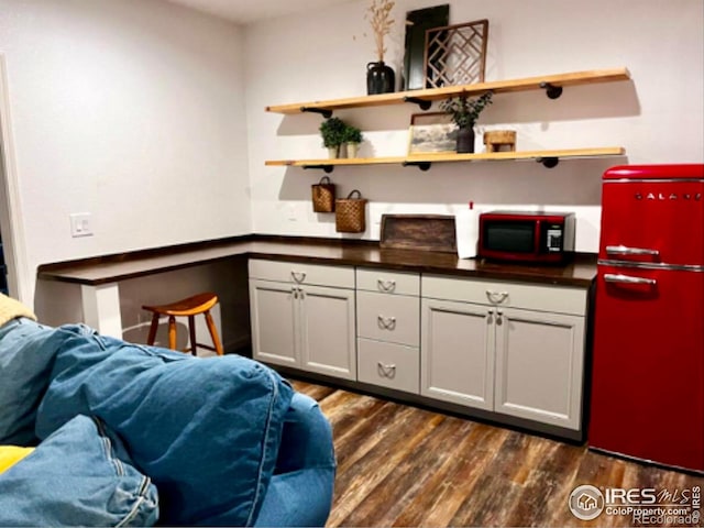 8241 White Owl Ct, Windsor, CO 80550 - kitchen with fridge, dark countertops, dark wood-style flooring, and open floor plan