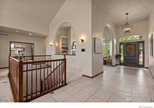 7717 Amour Hill Dr, Greeley, CO 80634 - tiled entryway with a towering ceiling, baseboards, a chandelier, arched walkways, and recessed lighting