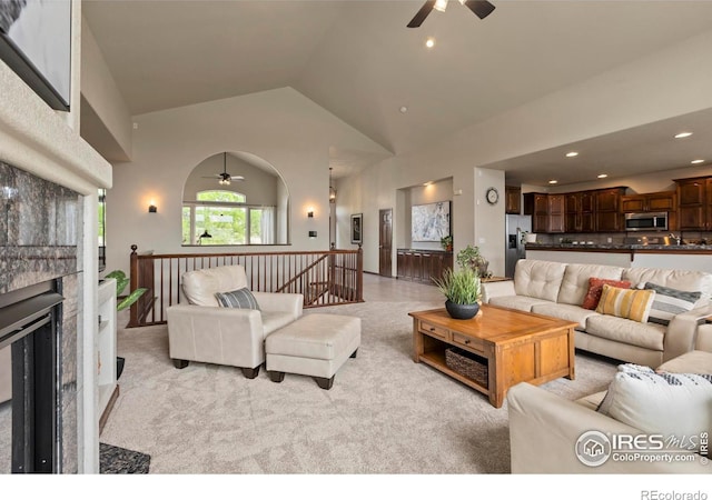 7717 Amour Hill Dr, Greeley, CO 80634 - living room featuring a ceiling fan, light carpet, high vaulted ceiling, a large fireplace, and recessed lighting