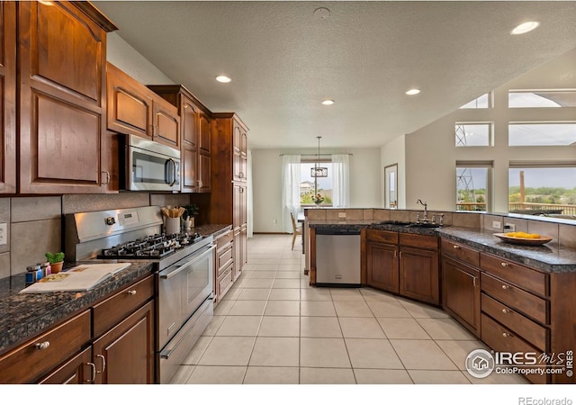 7717 Amour Hill Dr, Greeley, CO 80634 - kitchen featuring stainless steel appliances, a sink, recessed lighting, light tile patterned flooring, and tasteful backsplash