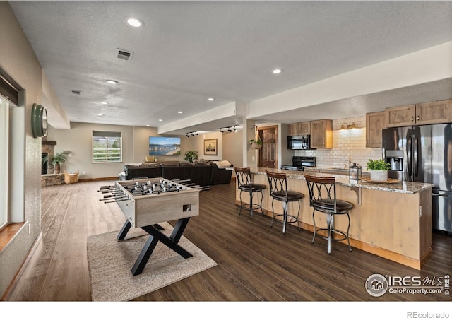 7717 Amour Hill Dr, Greeley, CO 80634 - recreation room with dark wood finished floors, a textured ceiling, recessed lighting, and a sink