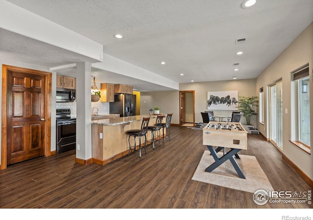 7717 Amour Hill Dr, Greeley, CO 80634 - playroom with dark wood-style floors, recessed lighting, baseboards, a sink, and a textured ceiling