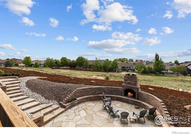 7717 Amour Hill Dr, Greeley, CO 80634 - view of patio with an outdoor stone fireplace and a residential view