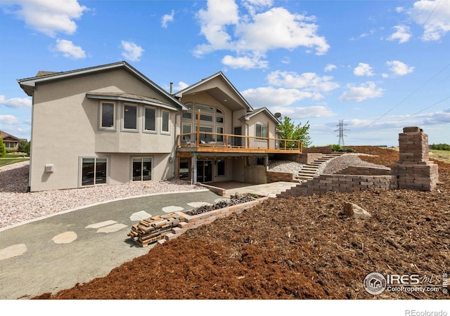 7717 Amour Hill Dr, Greeley, CO 80634 - back of house featuring stucco siding, a wooden deck, stairs, and a patio
