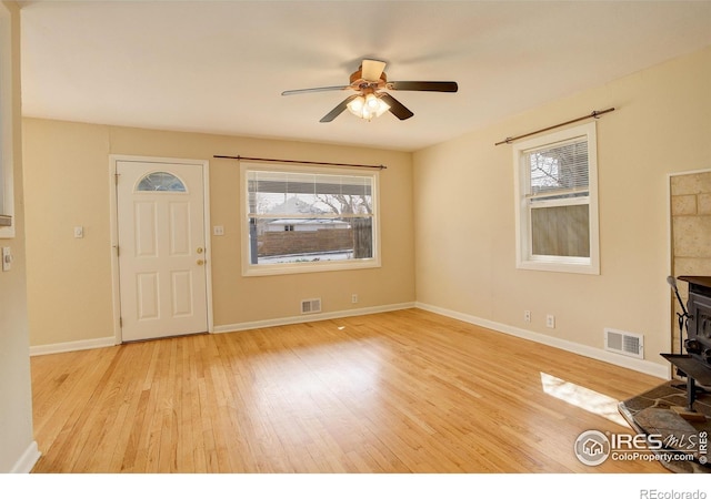 503 E Oak St, Lafayette, CO 80026 - unfurnished living room with wood finished floors, plenty of natural light, ceiling fan, and a wood stove