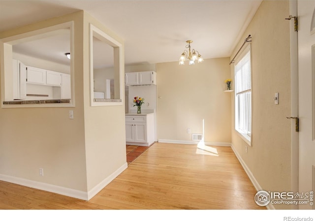 503 E Oak St, Lafayette, CO 80026 - unfurnished dining area featuring light wood finished floors, a chandelier, and baseboards
