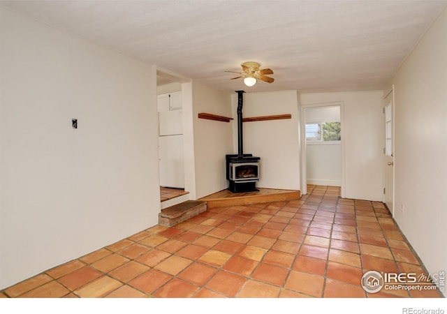503 E Oak St, Lafayette, CO 80026 - unfurnished living room featuring ceiling fan, a wood stove, and light tile patterned floors