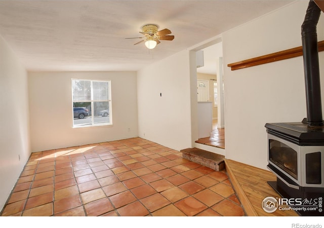 503 E Oak St, Lafayette, CO 80026 - unfurnished living room with a wood stove, ceiling fan, and tile patterned flooring