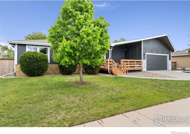 512 Prairie Clover Way, Severance, CO 80550 - view of front of property with a garage, concrete driveway, a wooden deck, and a front lawn