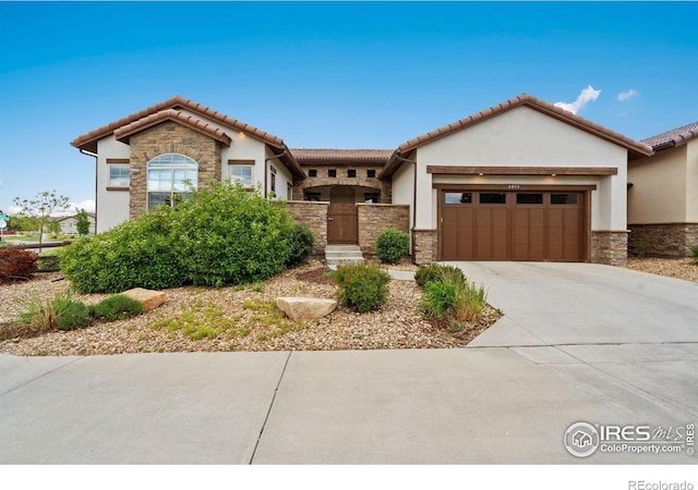 4014 Rock Creek Dr, Fort Collins, CO 80528 - view of front facade with stone siding, a garage, and stucco siding