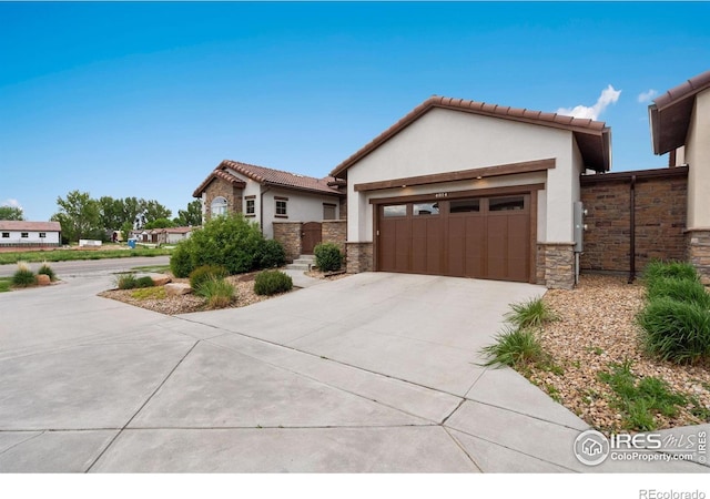 4014 Rock Creek Dr, Fort Collins, CO 80528 - view of front of house featuring stucco siding, driveway, an attached garage, stone siding, and a tiled roof