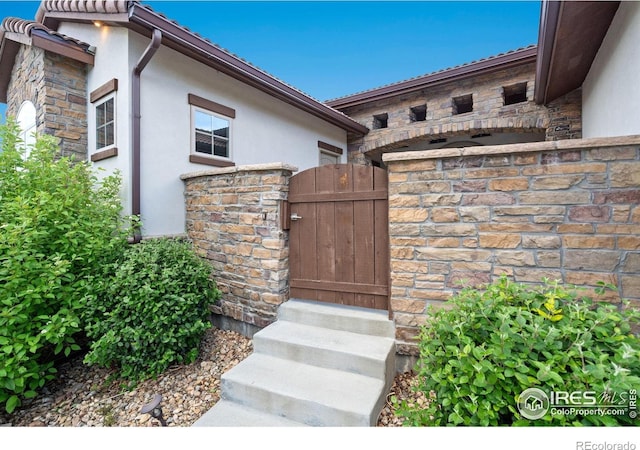 4014 Rock Creek Dr, Fort Collins, CO 80528 - entrance to property featuring stucco siding, stone siding, and a gate