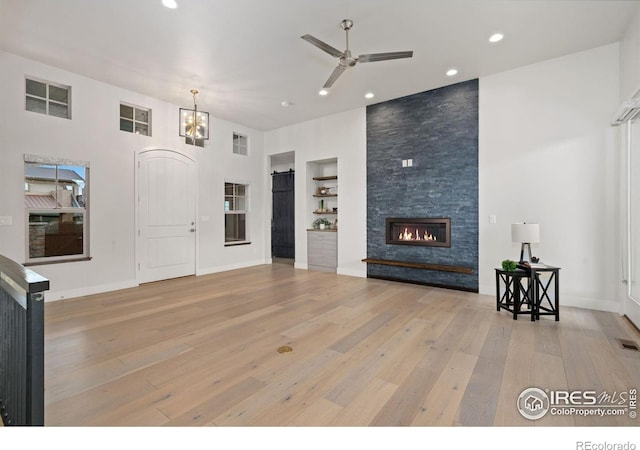 4014 Rock Creek Dr, Fort Collins, CO 80528 - unfurnished living room with light wood-style flooring, ceiling fan, built in features, a fireplace, and recessed lighting