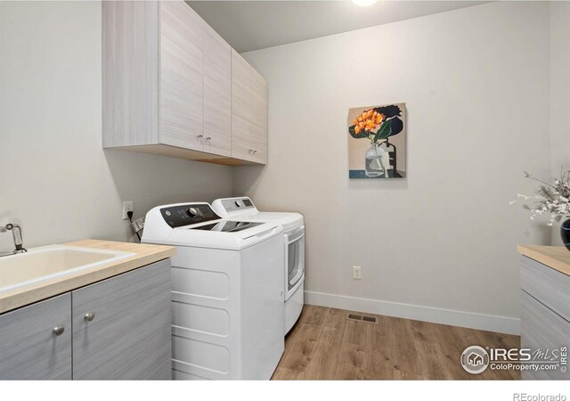 4014 Rock Creek Dr, Fort Collins, CO 80528 - laundry area with cabinet space, light wood-style floors, washing machine and clothes dryer, and baseboards