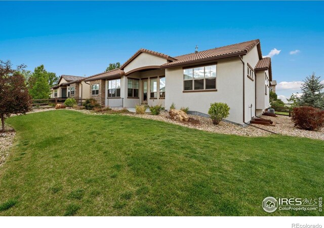 4014 Rock Creek Dr, Fort Collins, CO 80528 - rear view of property with a yard, a tiled roof, and stucco siding