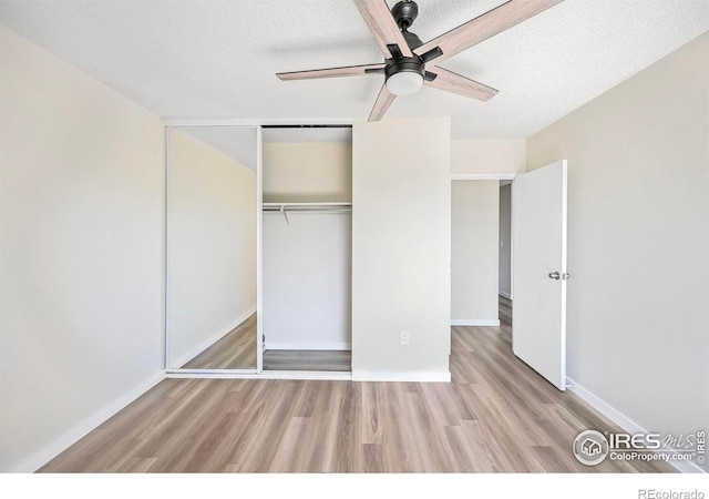 4110 Hale Pkwy # 5F, Denver, CO 80220 - unfurnished bedroom with wood finished floors, a textured ceiling, baseboards, a closet, and a ceiling fan
