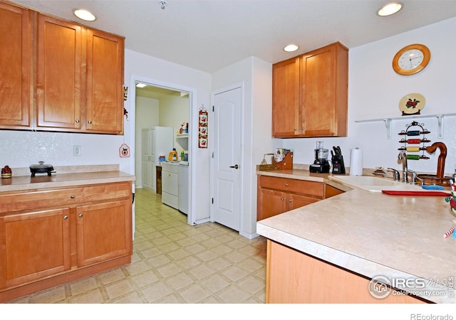 5014 Northern Lights Dr, Fort Collins, CO 80528 - kitchen featuring light flooring, washing machine and clothes dryer, light countertops, recessed lighting, and brown cabinetry