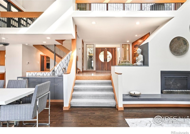 3746 Wonderland Hill Ave, Boulder, CO 80304 - stairway featuring wood finished floors, a towering ceiling, a glass covered fireplace, and recessed lighting