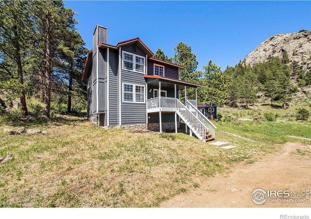 60 Horn Peak Dr, Livermore, CO 80536 - back of house featuring a chimney, stairway, and a deck